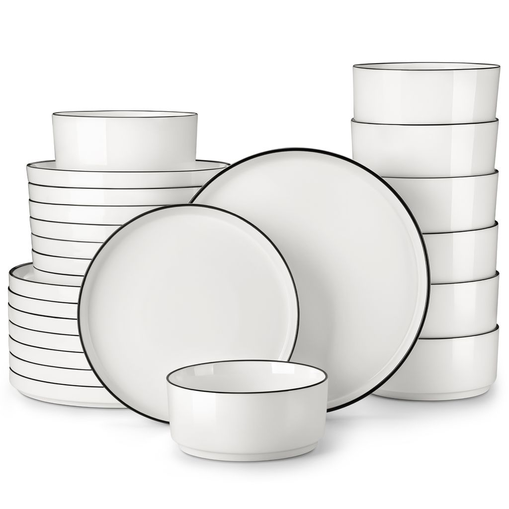 A collection of white ceramic plates and bowls with thin black rims, neatly stacked and arranged.
