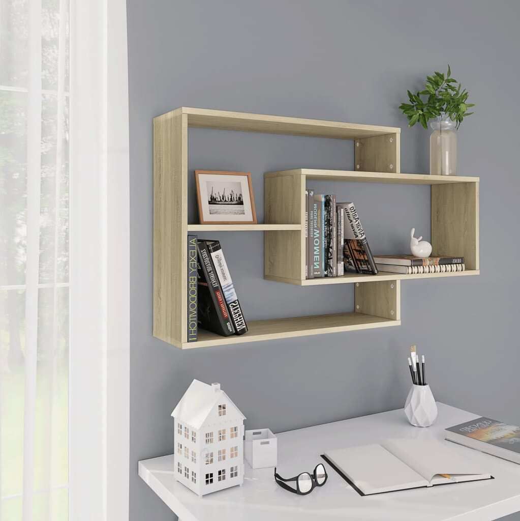 A light oak wood floating shelf unit is mounted on a gray wall above a white desk.