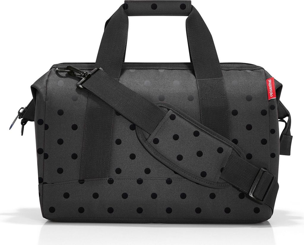 A black duffel bag with a polka dot pattern.