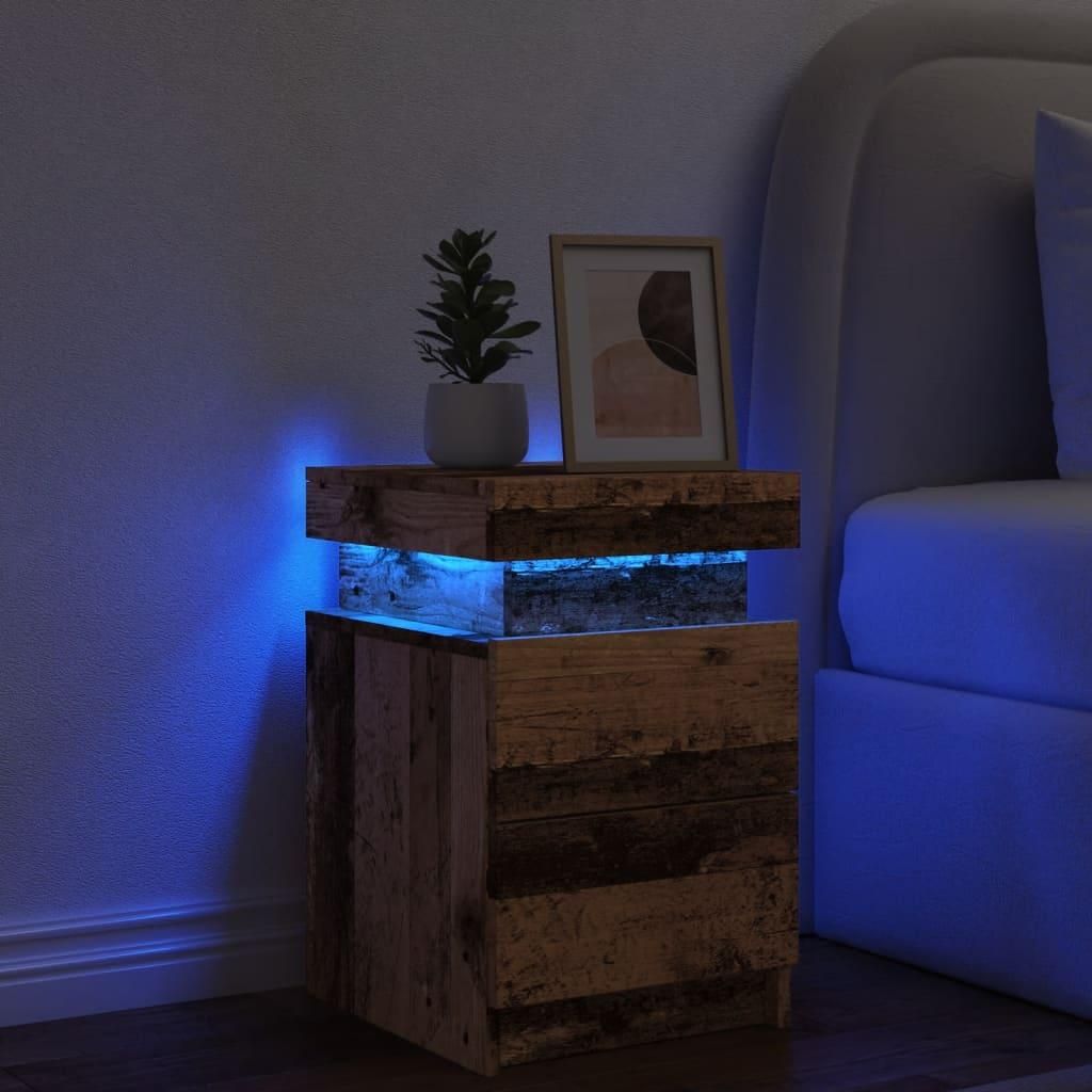 A bedside table with LED lighting next to a bed.