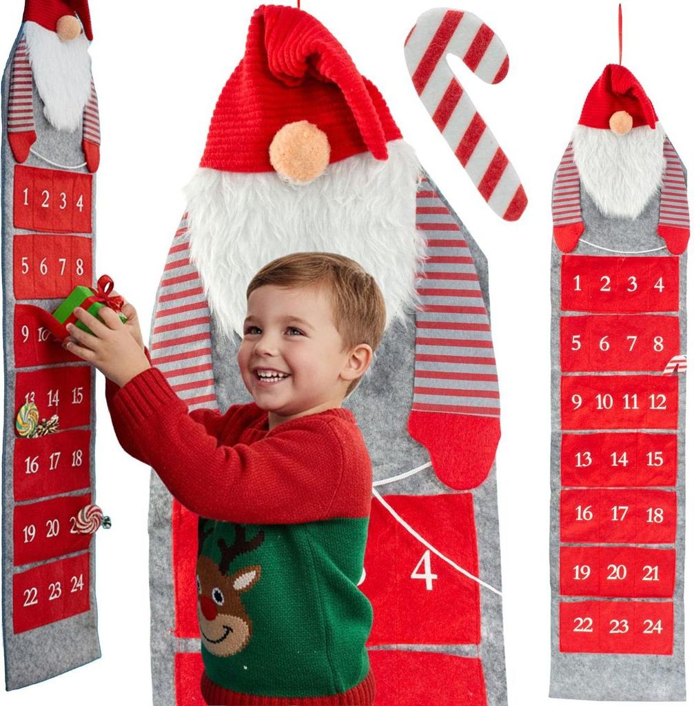 A young boy is interacting with a large, hanging Christmas advent calendar shaped like a gnome.