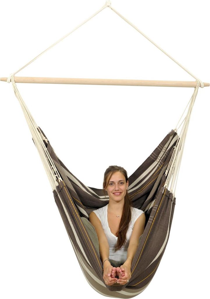 A woman sits in a hammock chair.