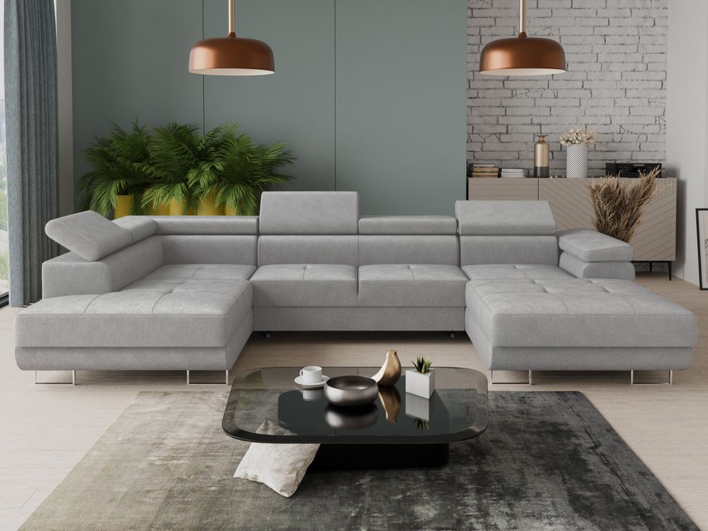 A modern living room with a large sectional sofa, coffee table, and plants.