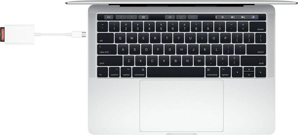 A top-down view of a laptop with a USB-C to SD card reader plugged into its side.
