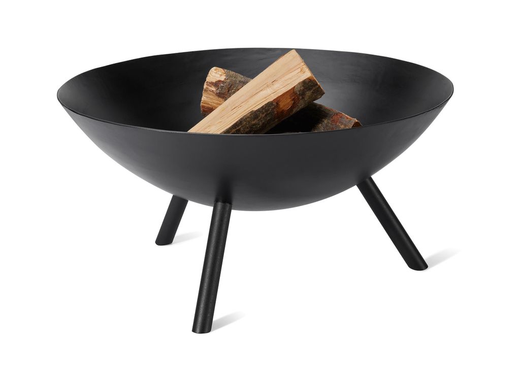 A black metal fire bowl with three legs, containing two pieces of firewood, set against a white background.