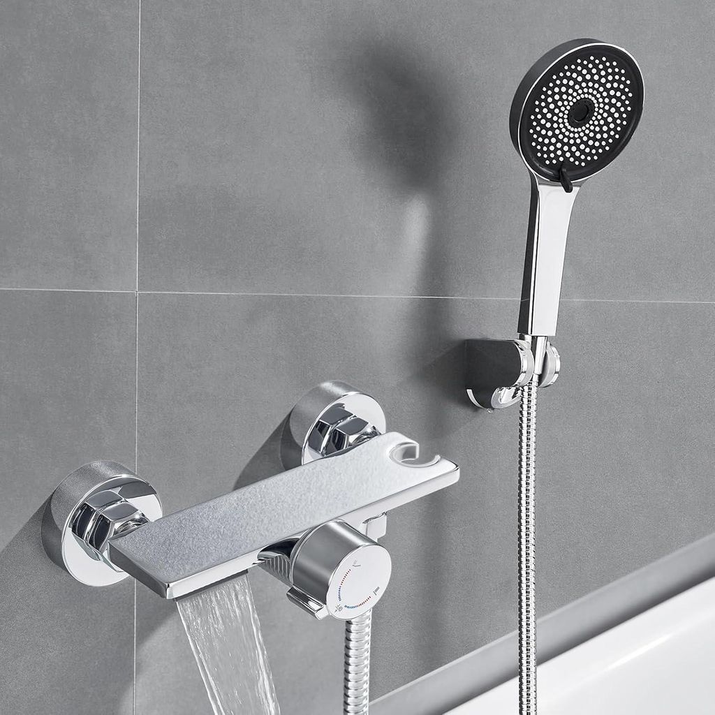 A modern bathroom faucet with a waterfall spout and a handheld showerhead mounted on a tiled wall.