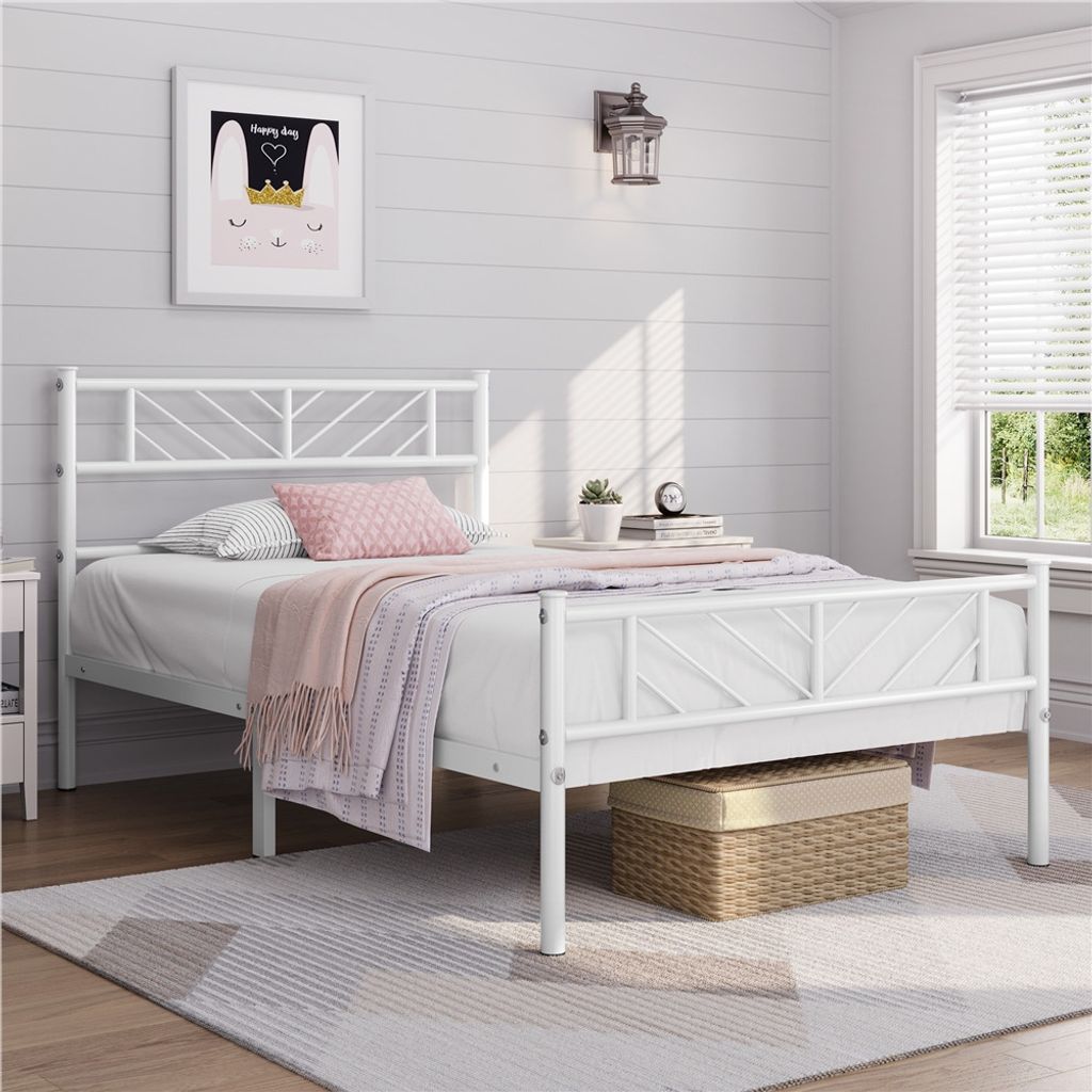 A white metal bed frame with bedding in a bedroom setting.