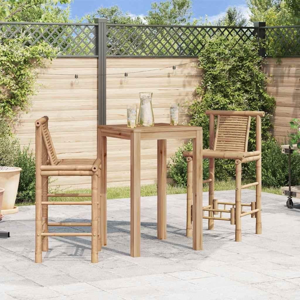 A patio scene with a bar table and two bar stools made of bamboo, set against a wooden fence and greenery.