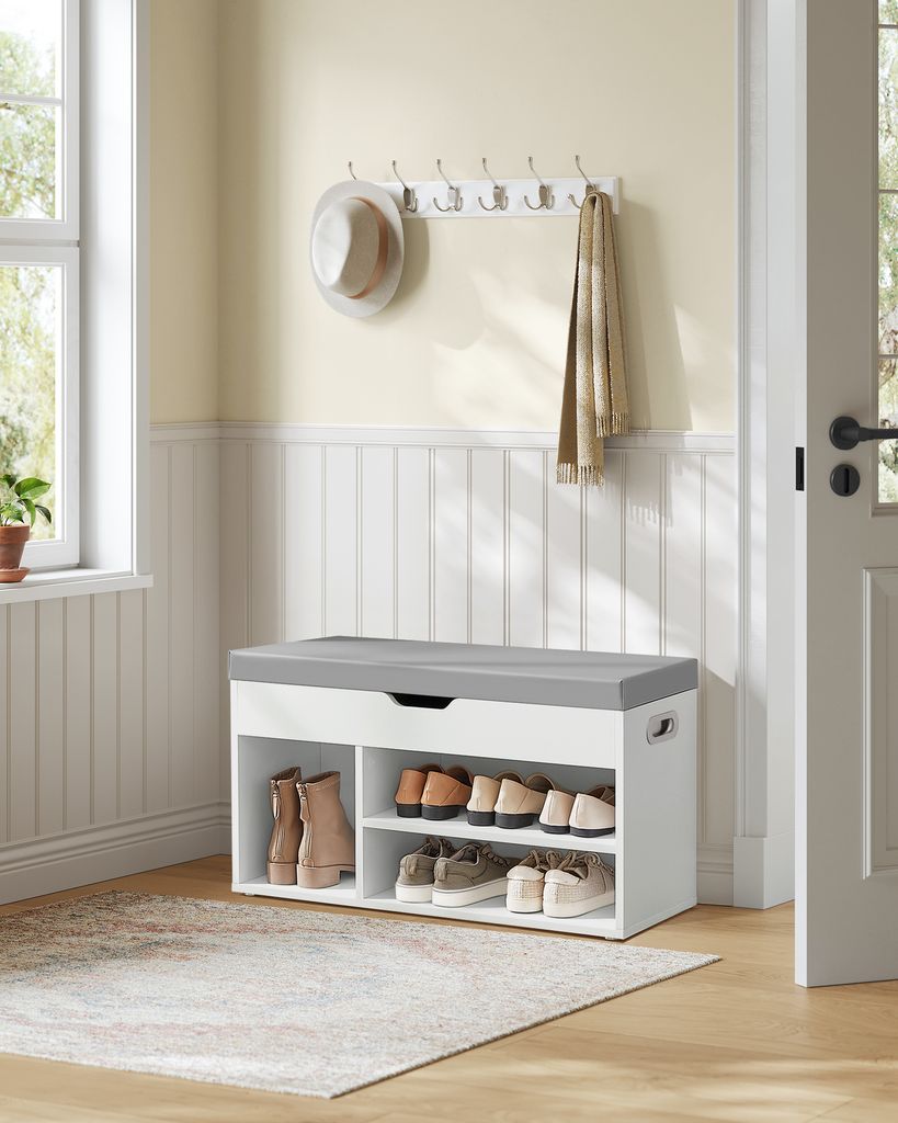An entryway with a shoe bench, coat rack, and hat.