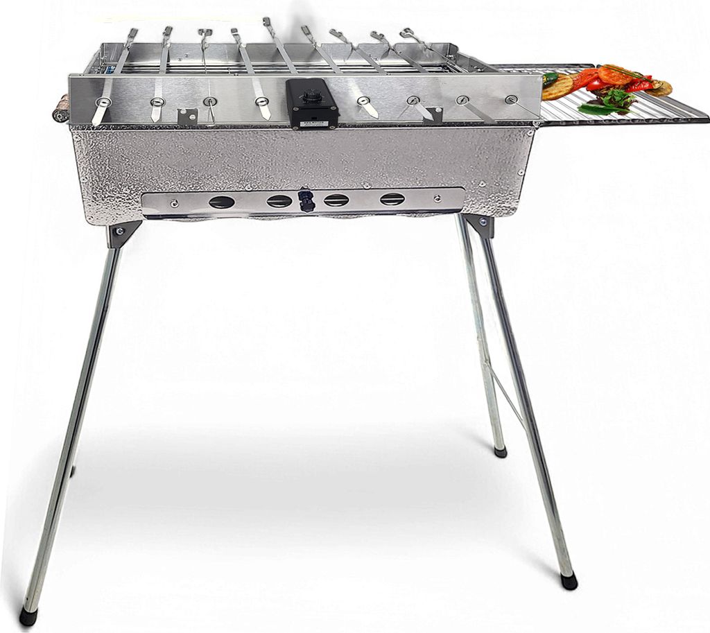 A stainless steel barbecue grill with folding legs, skewers, and a small rack of vegetables on the side.