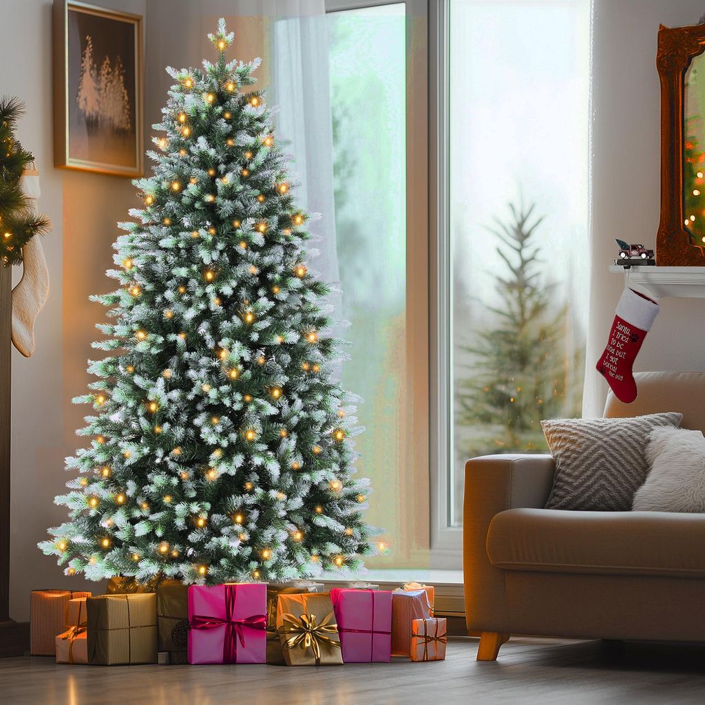 A decorated Christmas tree with presents underneath, next to a couch and a fireplace.