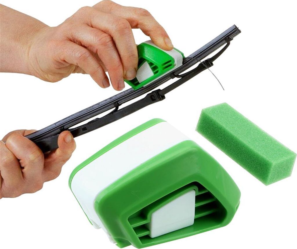 A person is using a green and white tool to clean a car windshield wiper blade. A green sponge and another part of the tool are also visible.