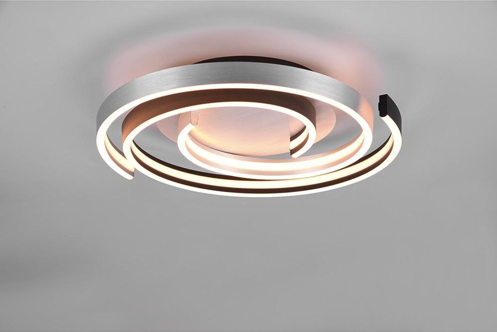 A modern LED ceiling light with a swirling design, mounted on a light gray ceiling.