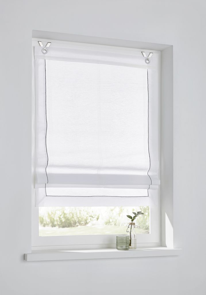 A white Roman blind with a subtle gray stitched trim is shown hanging in a window.