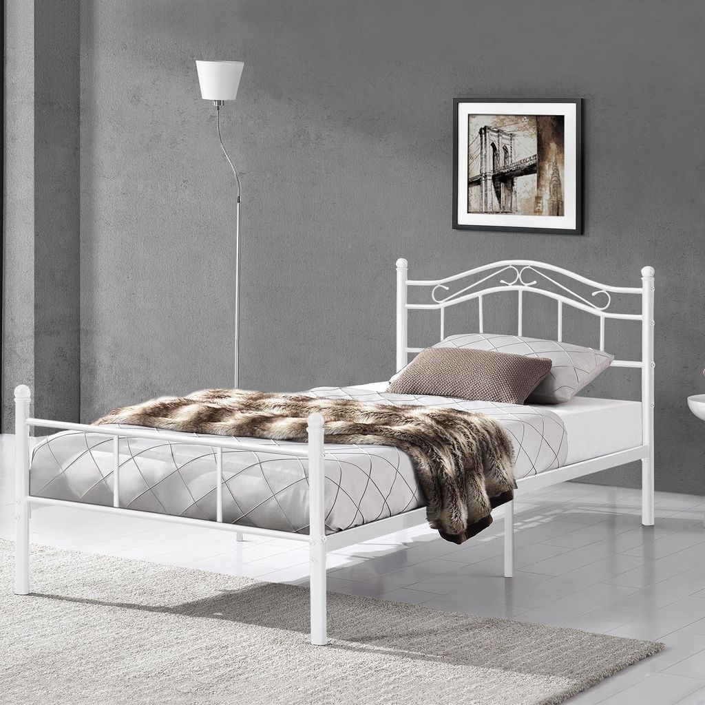 A white metal bed frame in a bedroom setting.