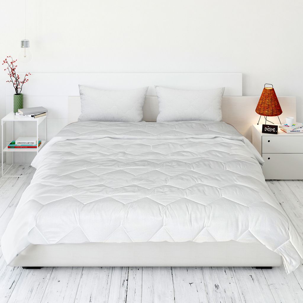 A neatly made bed with white bedding in a minimalist bedroom setting.