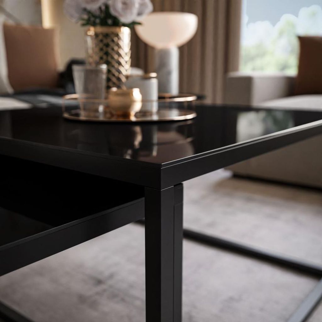 A close-up shot of a black coffee table with items on it in a living room setting.