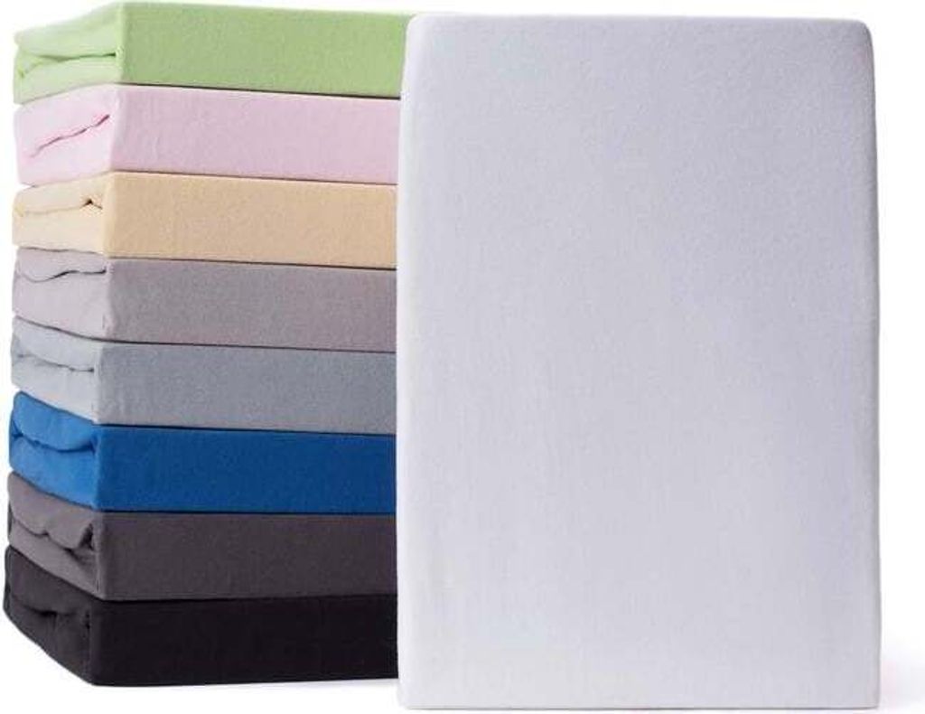 A stack of folded fitted sheets in various colors next to a white fitted sheet.