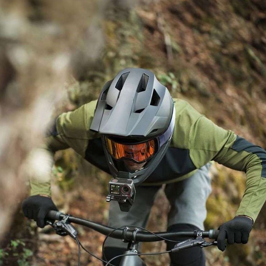 A person riding a mountain bike with a helmet-mounted camera.