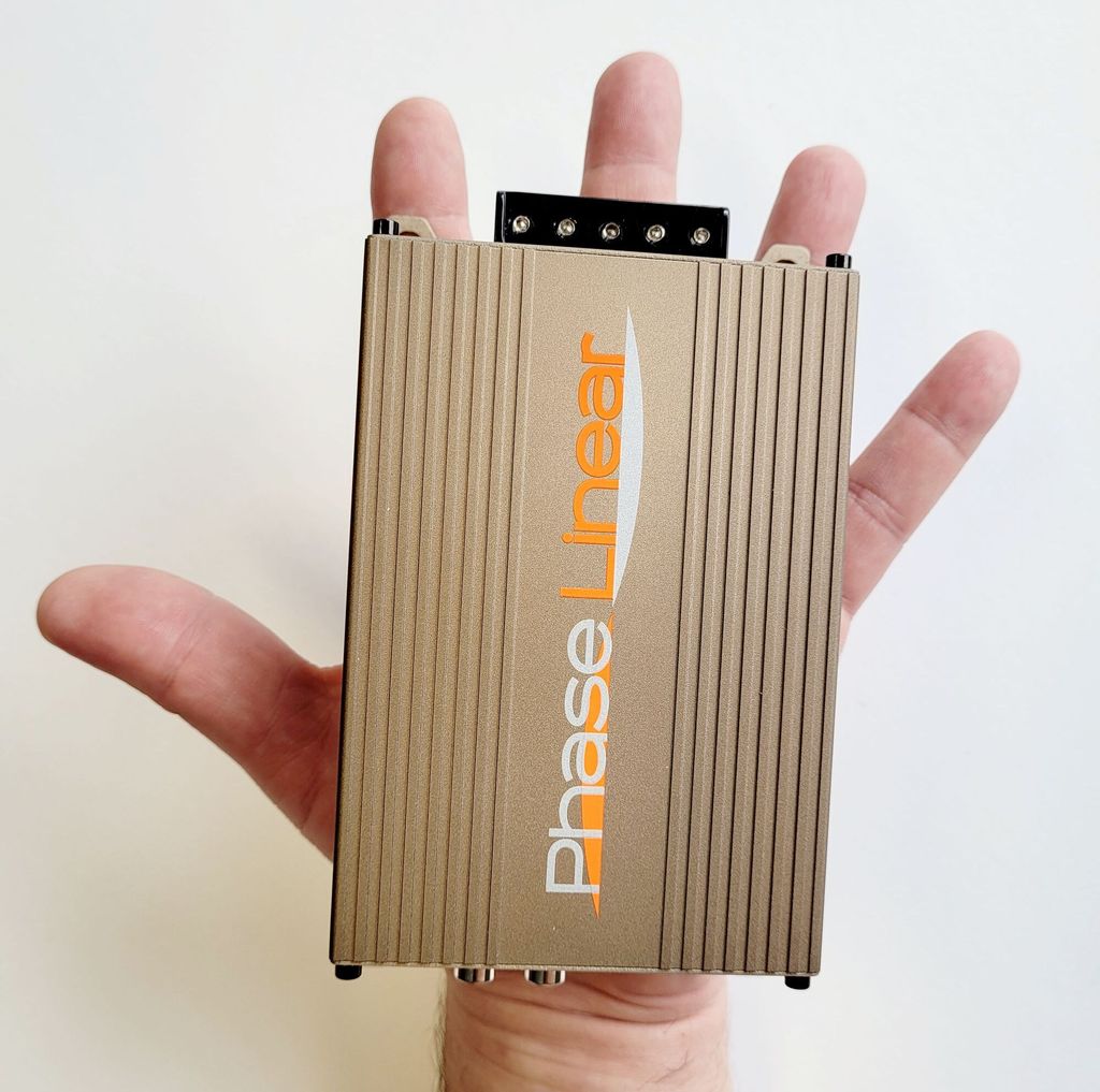 A hand holding a small electronic device.