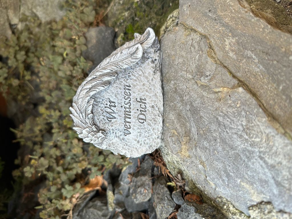 eberin · Friedhof Berührender Grabschmuck: Grabstein mit aufliegender Feder · Trauerstein reale Steinoptik mit Spruch Wir vermissen Dich