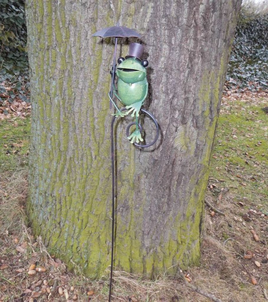 Gartendekoration. Frecher Frosch auf Gartenstab mit Zylinder u. Schirm