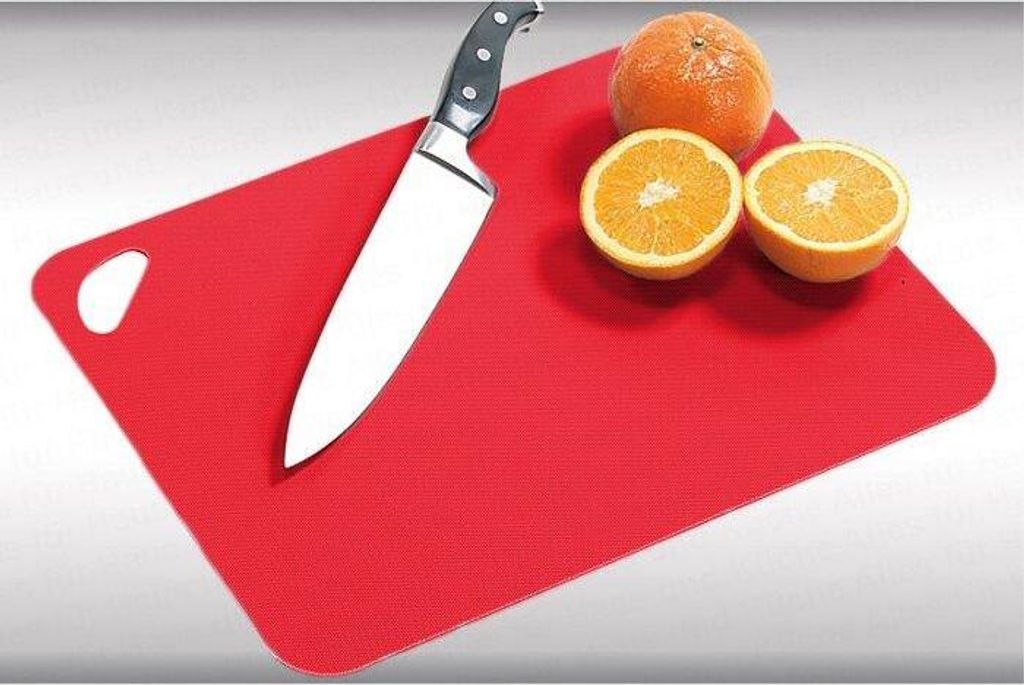 A red cutting board with a knife and oranges on it.