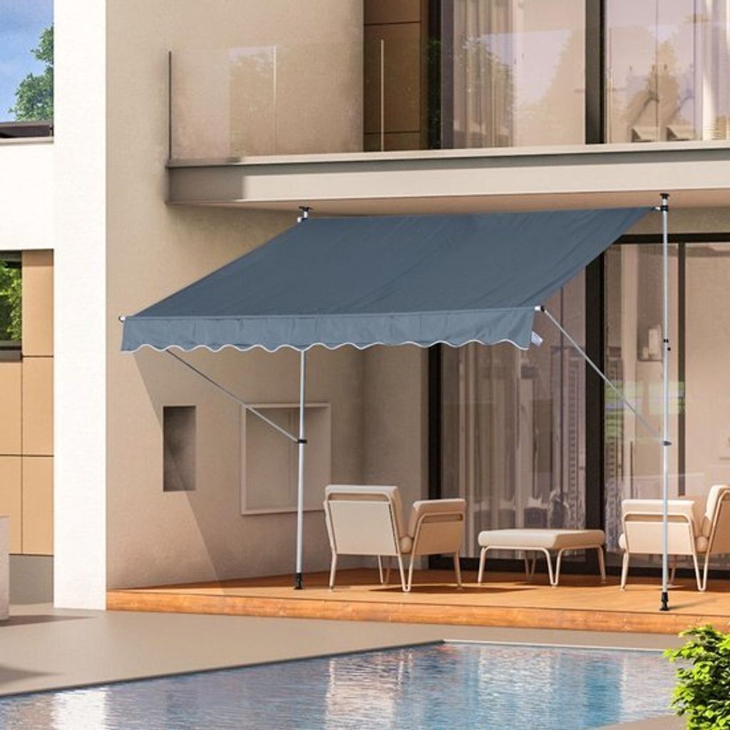 An awning is extended over a patio area next to a swimming pool.