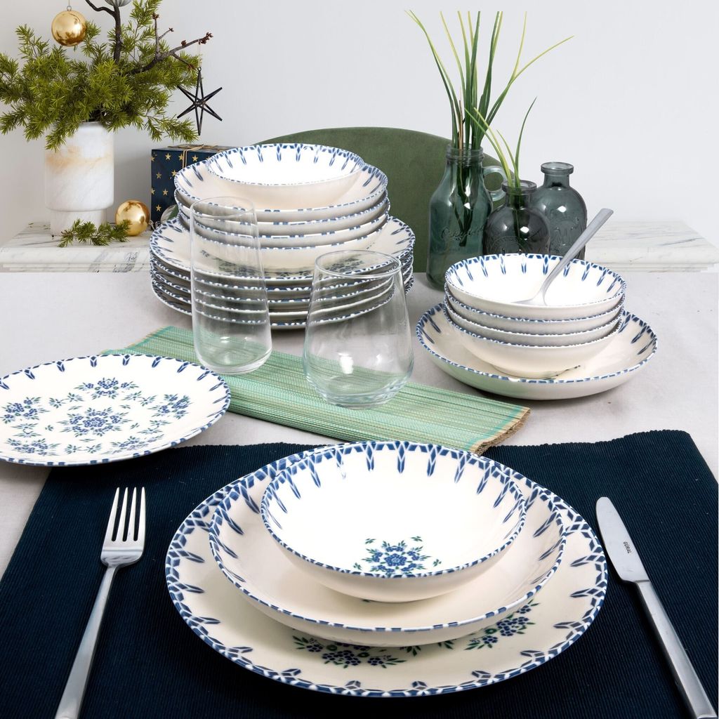 A table setting with a dinnerware set, glasses, and decorative elements.