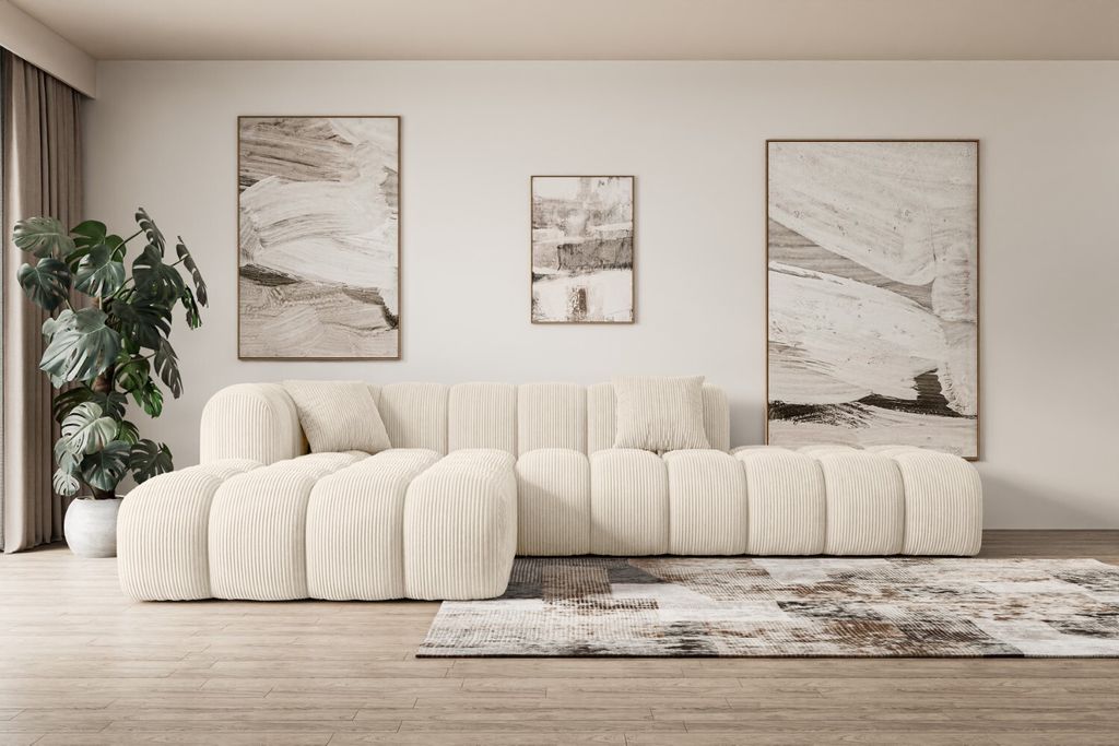 A modern living room with a large beige sectional sofa, abstract art on the wall, and a potted plant.