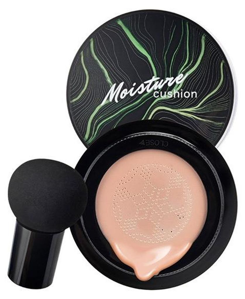 Schwarzes Cushion-Foundation-Kompakt mit grünem Blattdesign auf dem Deckel, geöffnet, um ein helles Pfirsich-Foundation und einen schwarzen pilzförmigen Make-up-Schwamm zu zeigen