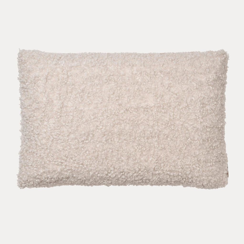 A rectangular, textured cushion cover in a light cream color, presented flat against a white background.