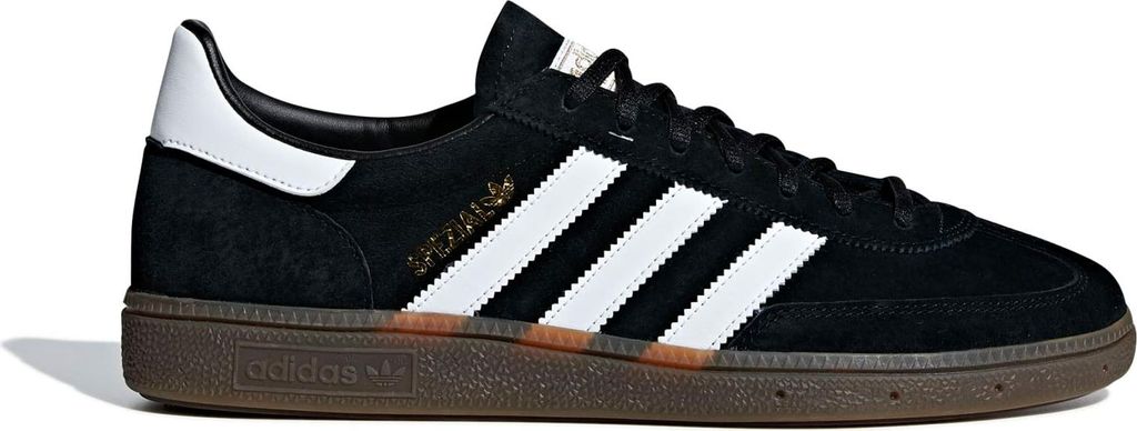 A black Adidas sneaker with white stripes and a brown sole, shown from the side against a white background.