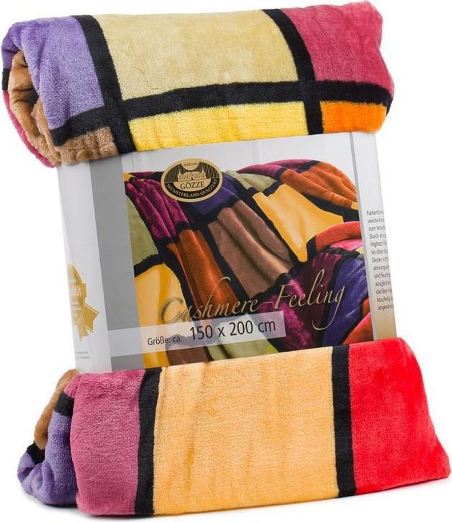 A folded blanket with a colorful geometric pattern is displayed on top of its packaging.