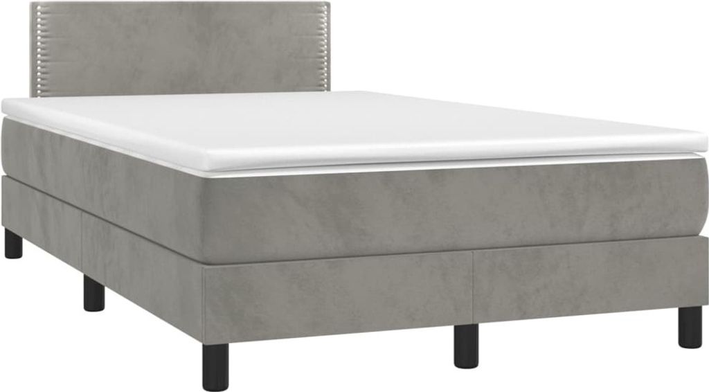 A studio shot of a gray box spring bed with a white mattress and a gray headboard.
