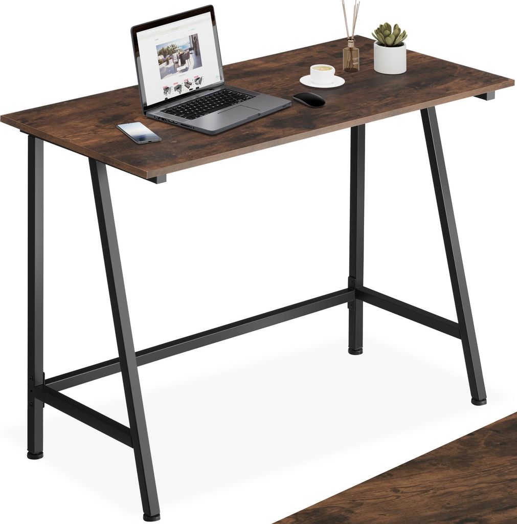 A desk with a laptop, coffee cup, and plant on it.