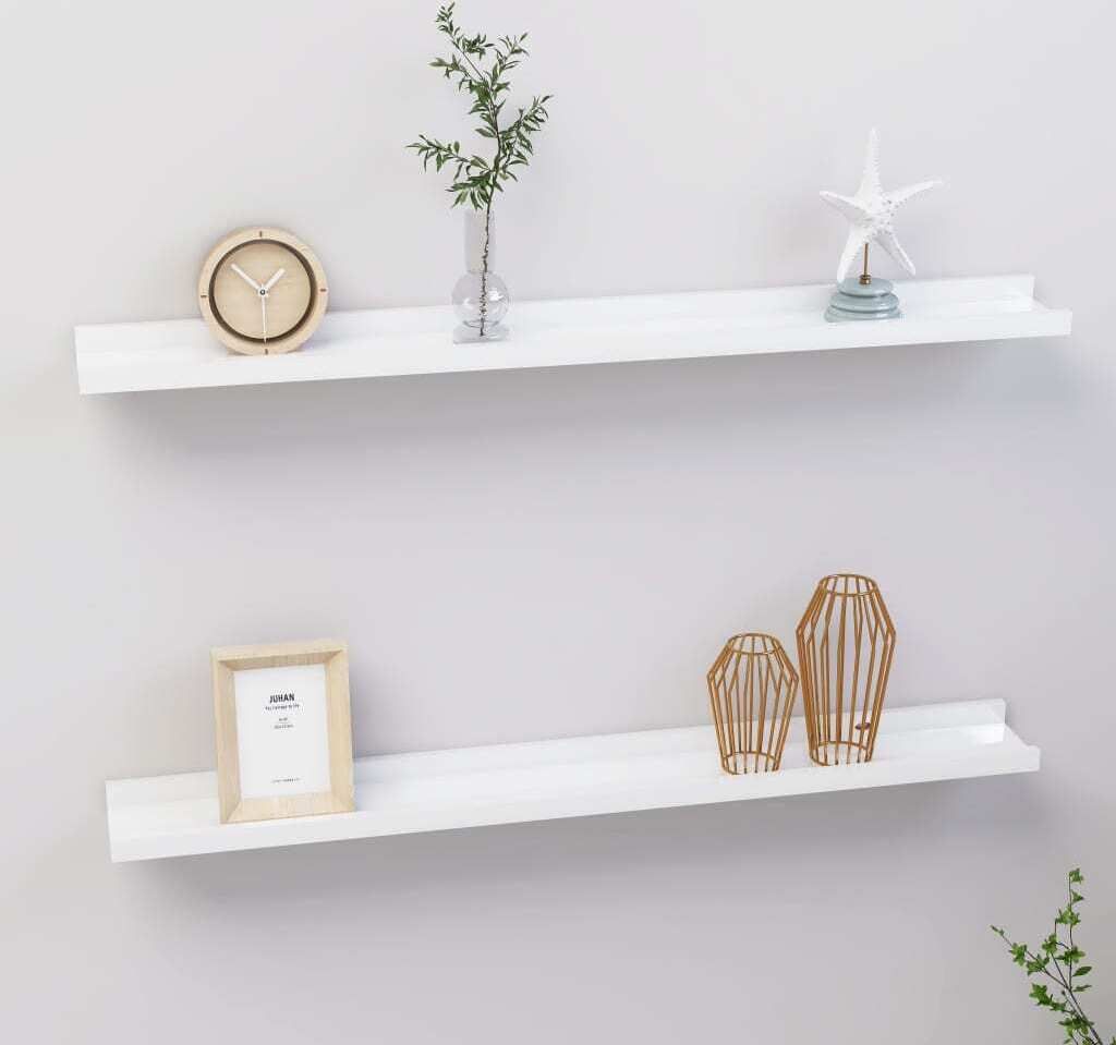 Two white shelves mounted on a light gray wall, each displaying decorative items.