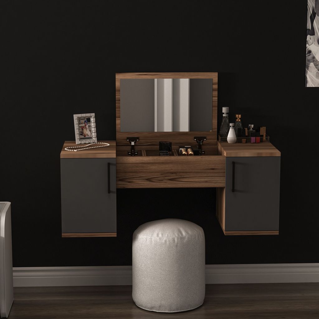 A modern vanity table with a mirror and two drawers, set against a black wall. A white pouf is placed in front of the table.