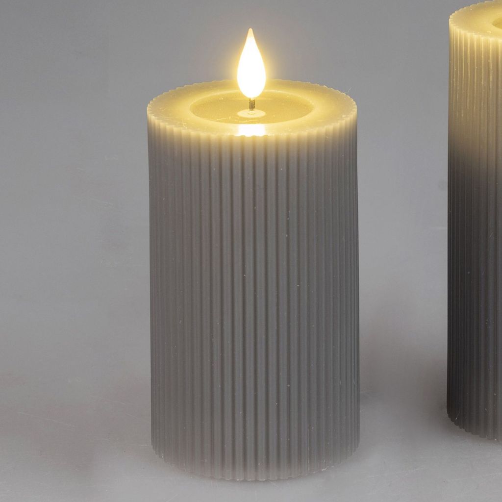 Two LED candles with a ribbed texture and a flickering flame are shown against a plain gray background.