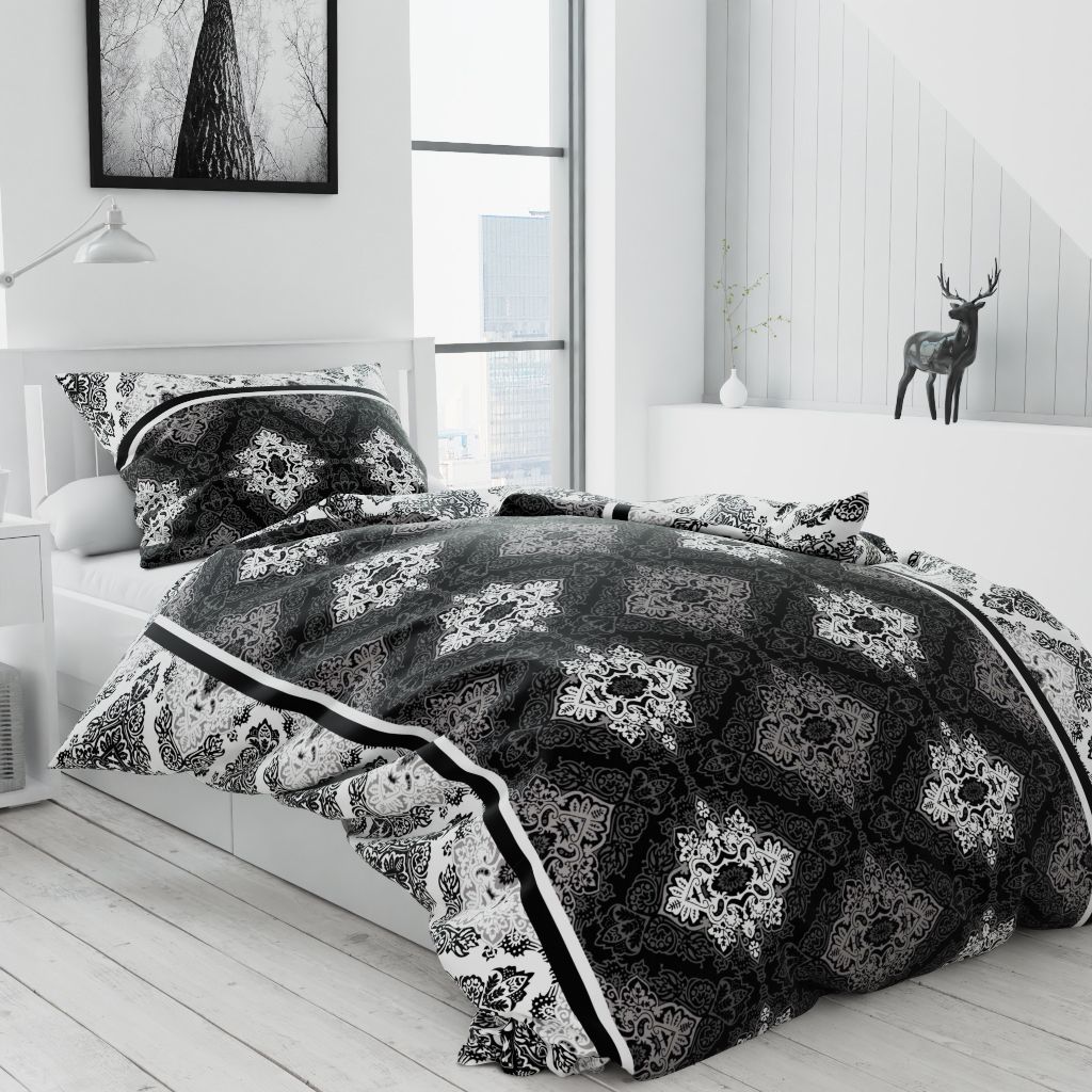 A bedroom scene with a bed made with black and white patterned bedding.