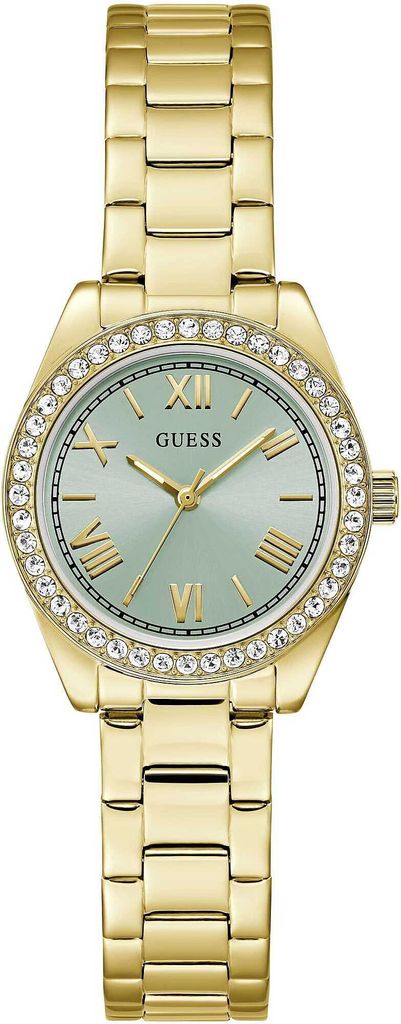 A close-up, studio shot of a gold-colored Guess watch with a light green face and crystal accents around the bezel.