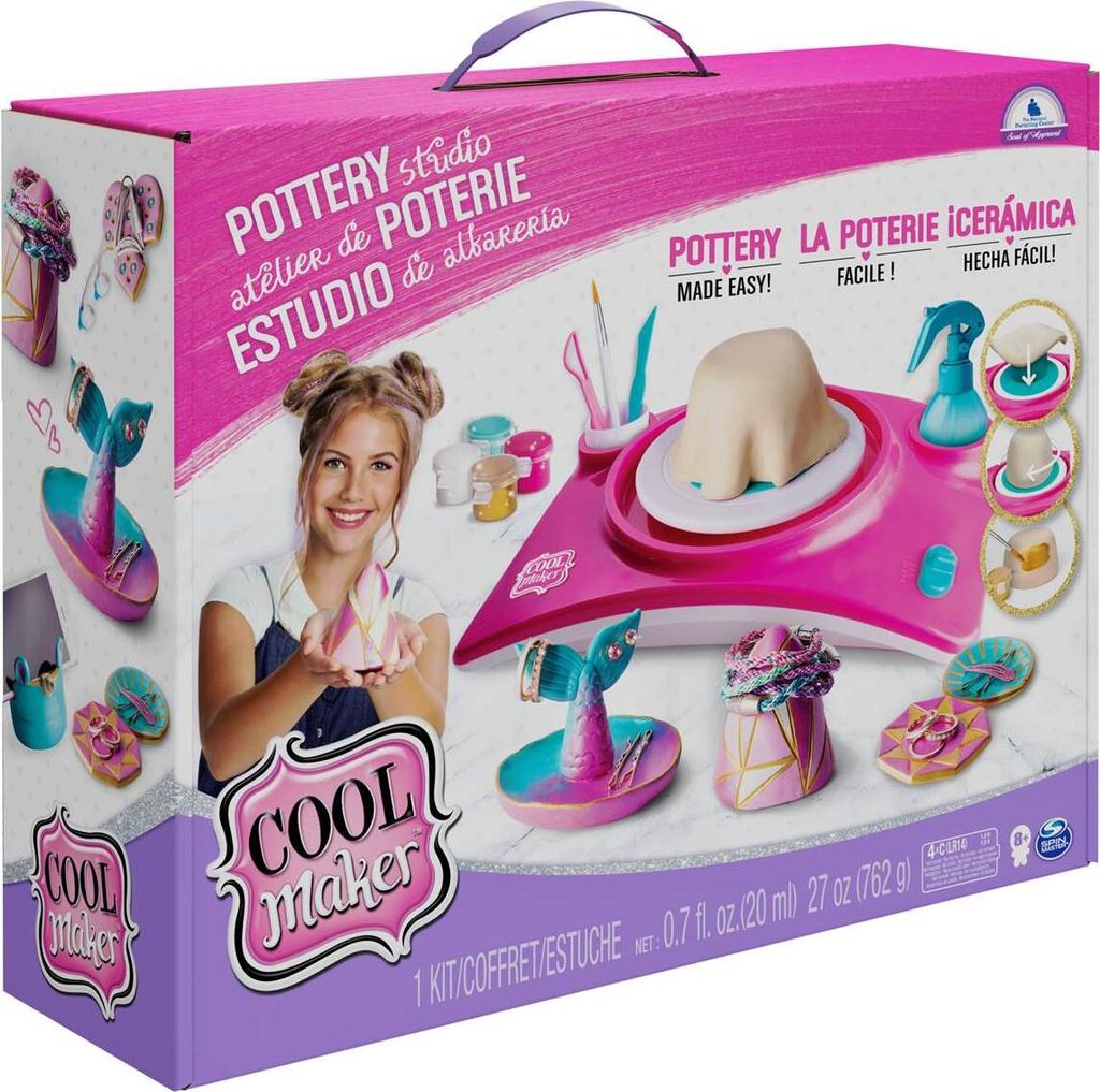 The image shows the product packaging for a pottery studio toy set. The box is pink and purple and features an image of a young girl holding a pottery piece, along with illustrations of the toy itself and its accessories.
