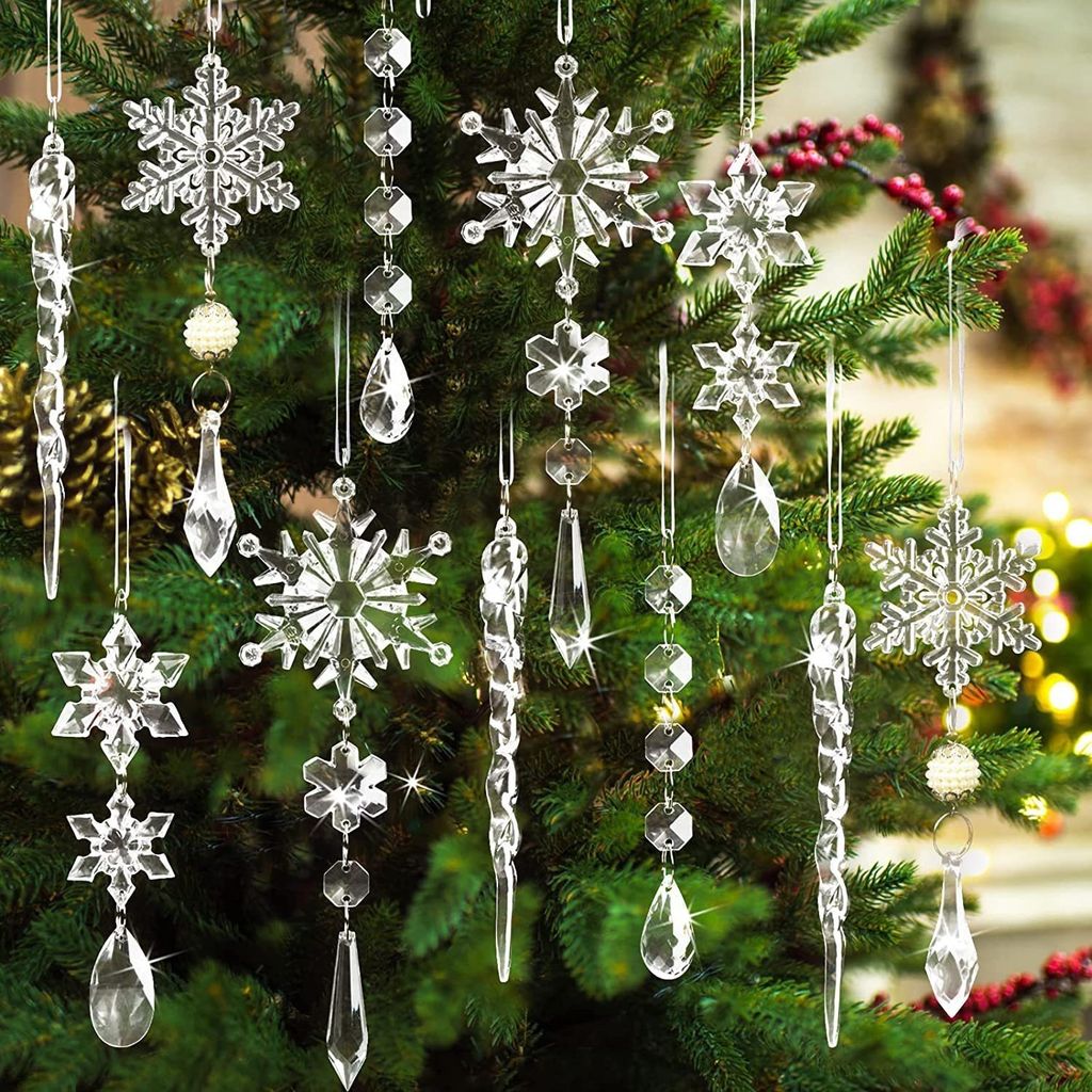 Christmas tree ornaments made of clear crystal in the shape of snowflakes and icicles hanging on a green Christmas tree.
