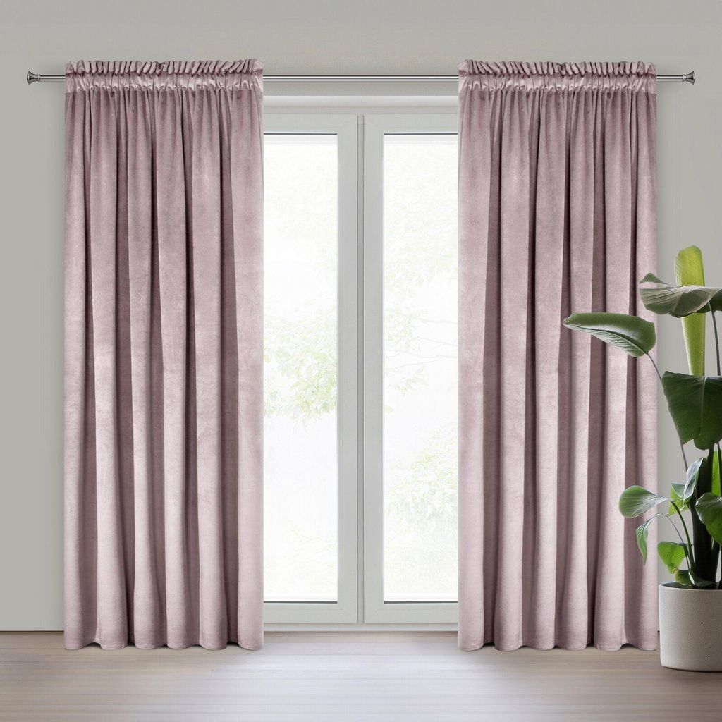 Two pink curtains are hung on a window rod in front of a window. A potted plant is visible to the right of the curtains.