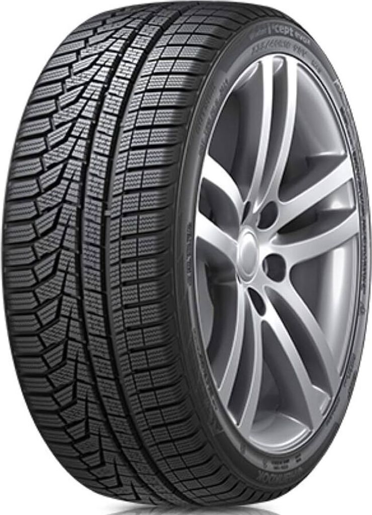 A close-up studio shot of a car tire mounted on a silver alloy wheel.