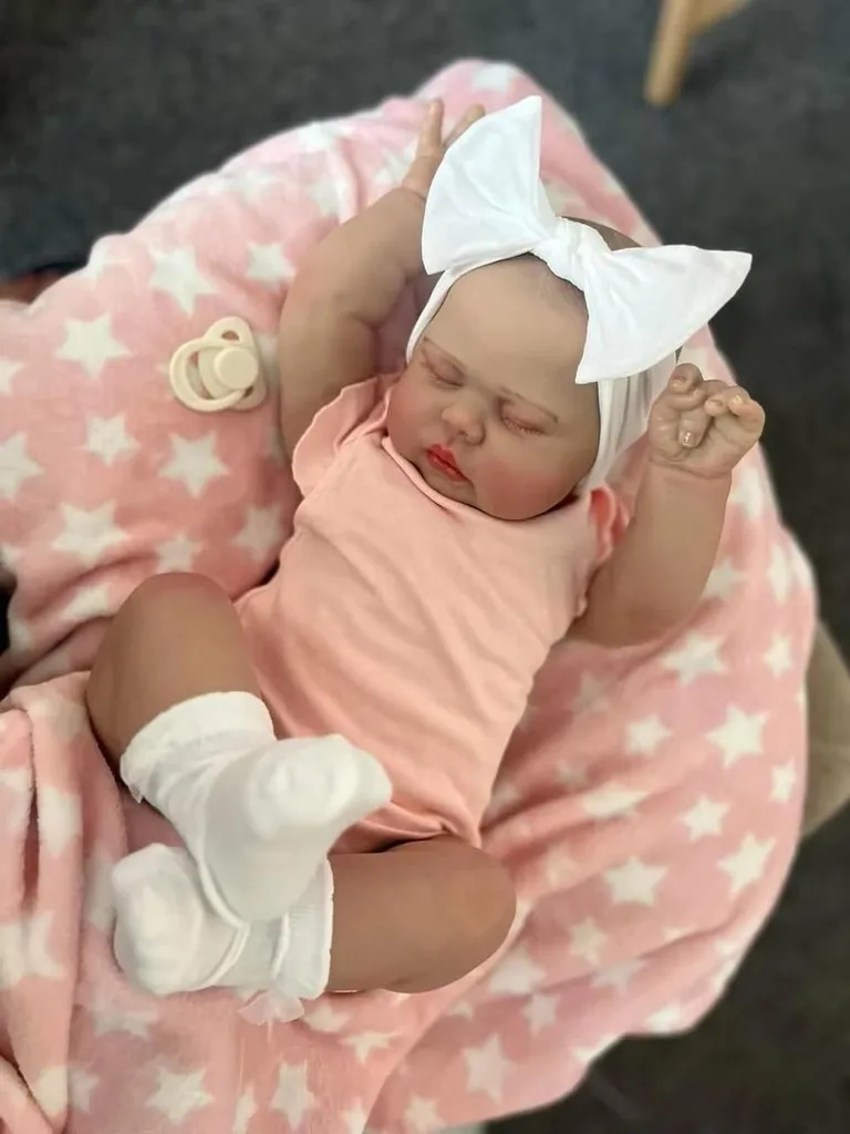 Poupée Reborn réaliste 60 cm corps coton et body rose aux yeux fermés
