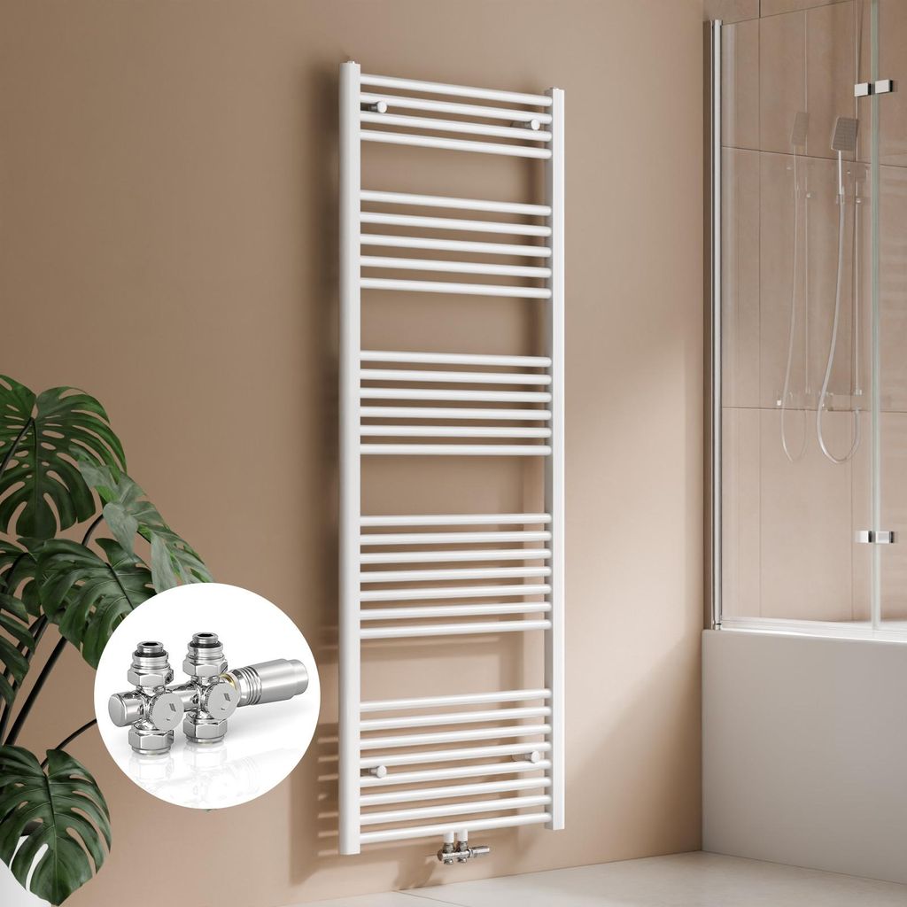 A white towel radiator is mounted on a tan wall next to a potted plant. A shower enclosure is visible in the background.