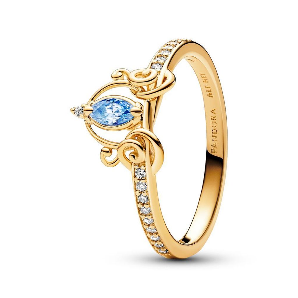 A close-up studio shot of a gold ring with a blue gemstone and clear accent stones.