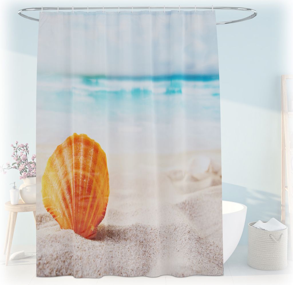 A shower curtain with a beach and seashell motif is displayed in a bathroom setting, partially obscuring a bathtub.