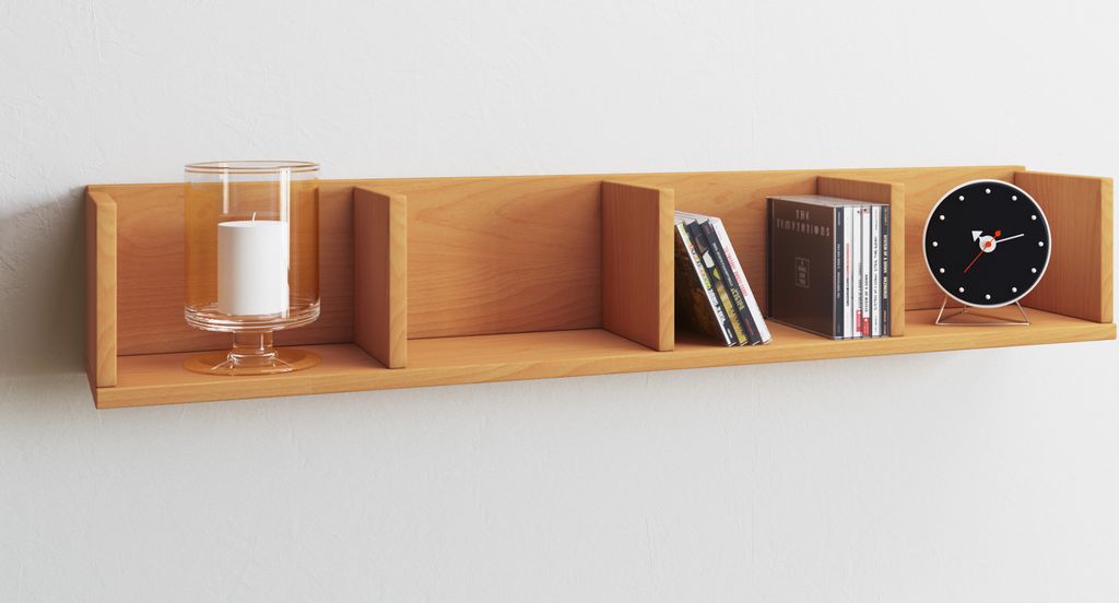 A wooden shelf mounted on a white wall, displaying decorative items and CDs.